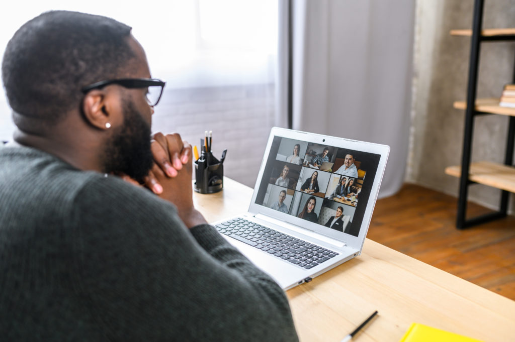 man using laptop to video chat for a marketing meeting